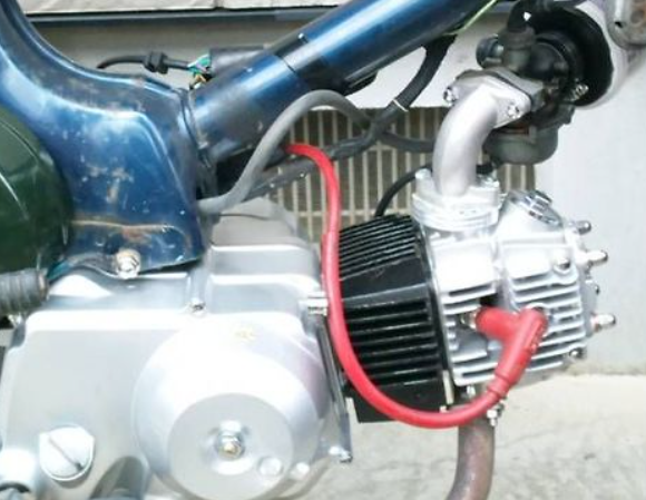 Close-up of a motorcycle engine with visible wiring and components.