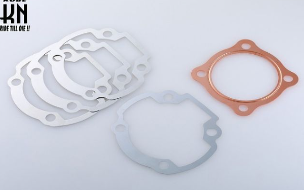 Three gaskets of different materials on a light gray background