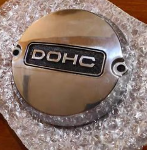 Metallic engine cover with 'DOHC' branding on a textured surface