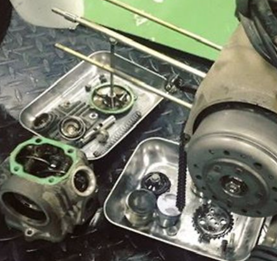 Mechanical parts on a metal tray with a green background