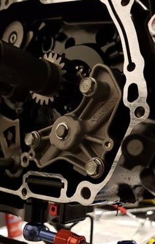 Close-up of a mechanical engine component with gears and bolts.