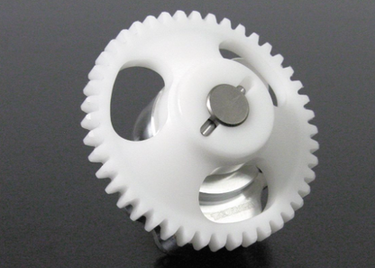 Close-up of two plastic gears on a dark background