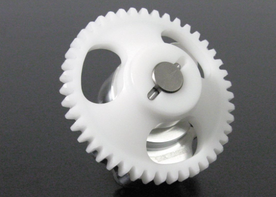 Close-up of two plastic gears on a dark background