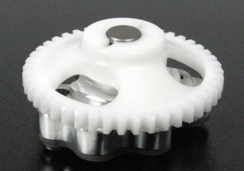White gear with metal components on a black background