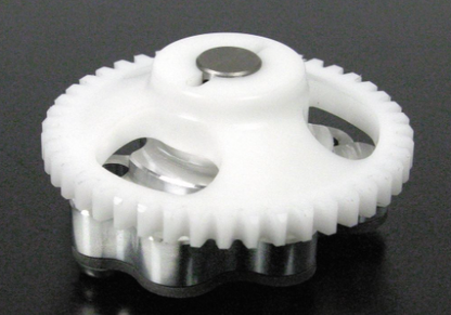 White gear with metal components on a black background