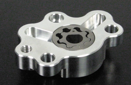 Metallic mechanical component with gear-like design on a black background
