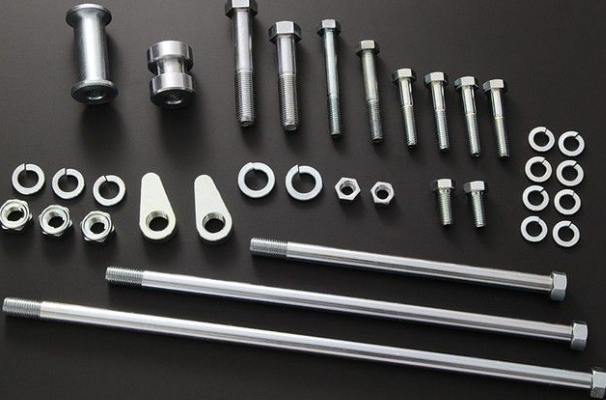 Collection of metal bolts, nuts, and washers on a black background