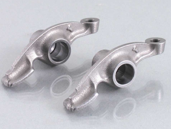 Two metallic mechanical components on a reflective surface
