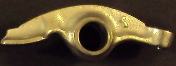 Metallic object with a central hole on a dark background