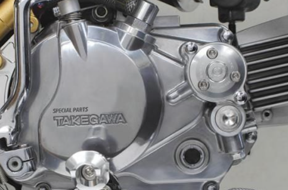 Close-up of a motorcycle engine with 'Takegawa' branding on a metallic surface.