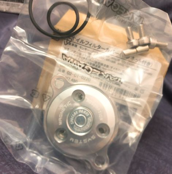 Mechanical component in clear packaging with visible branding on a purple surface