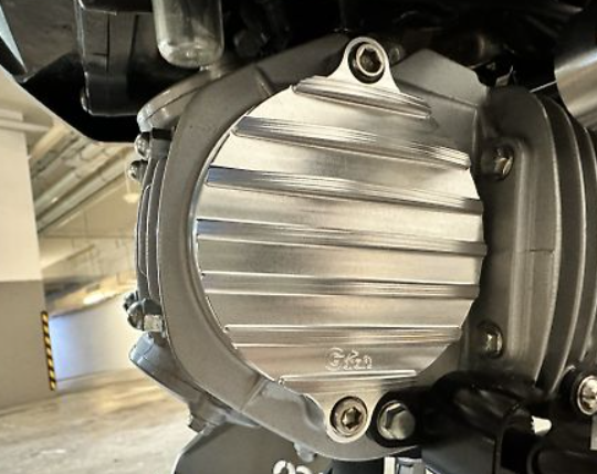Close-up of a motorcycle engine cover with 'Suzuki' branding.