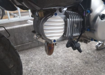 Close-up of a motorcycle engine and exhaust system on a concrete surface.