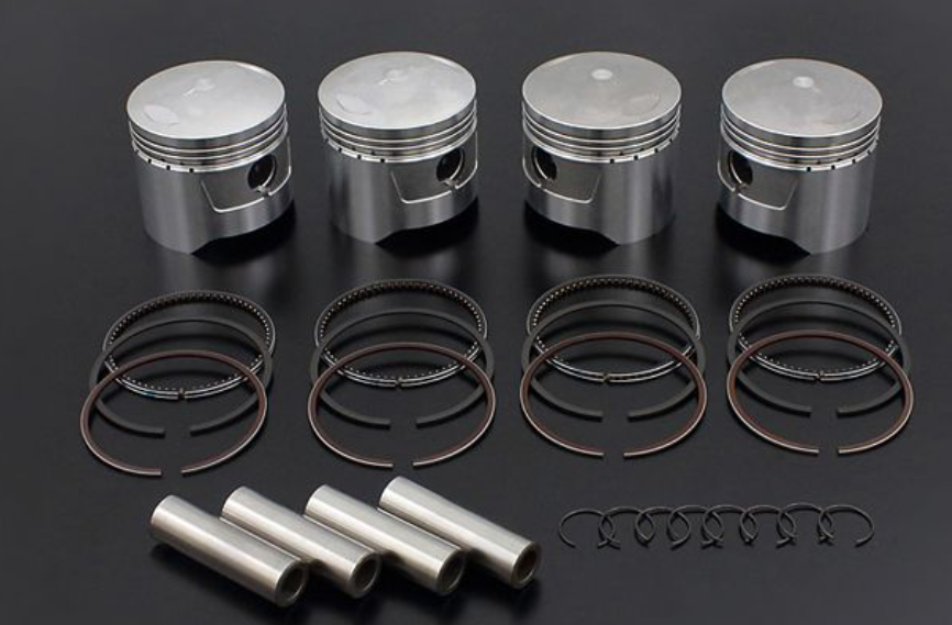 Set of piston rings and pins on a dark background