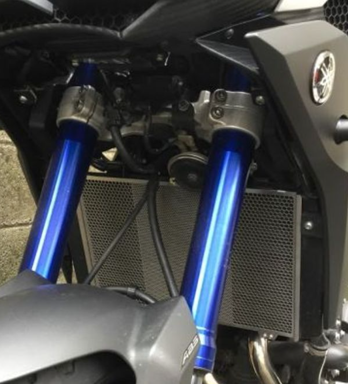 Close-up of a motorcycle with blue suspension forks and a visible brand logo.