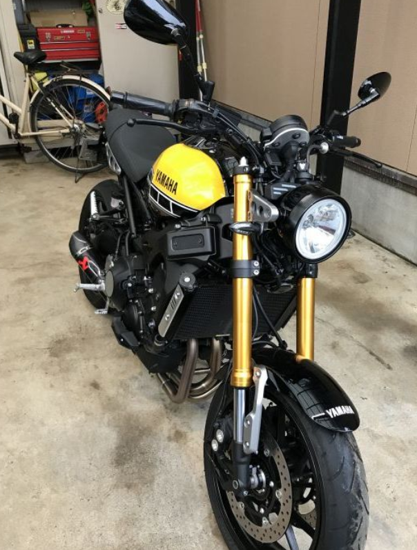 Black Yamaha motorcycle with gold forks in a garage setting
