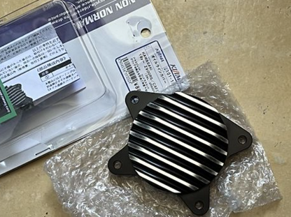 Black metal heat sink on a cardboard surface with packaging