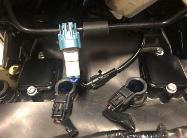 Car engine component with wiring and connectors on a metallic surface