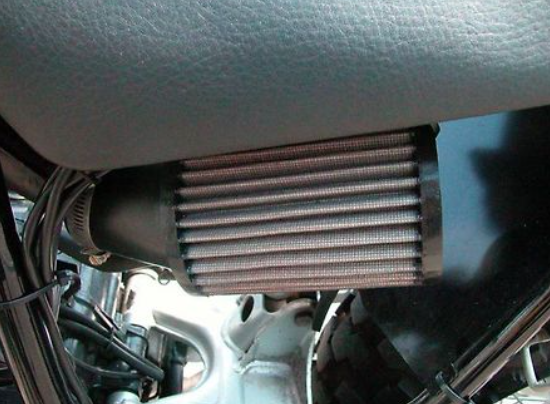 Close-up of a car's air conditioning condenser unit inside a vehicle.