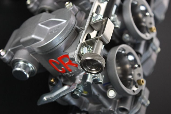Close-up of a mechanical engine component with 'CR' branding on a dark background