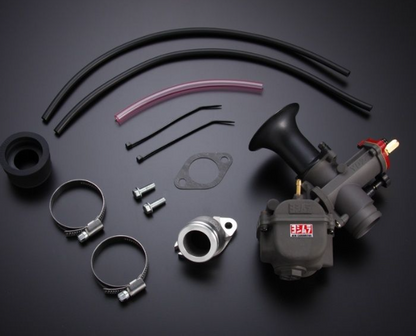 Automotive parts including a carburetor, hoses, and clamps on a dark background