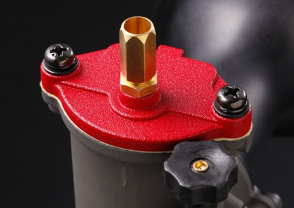 Close-up of a red and black mechanical component with gold accents on a dark background