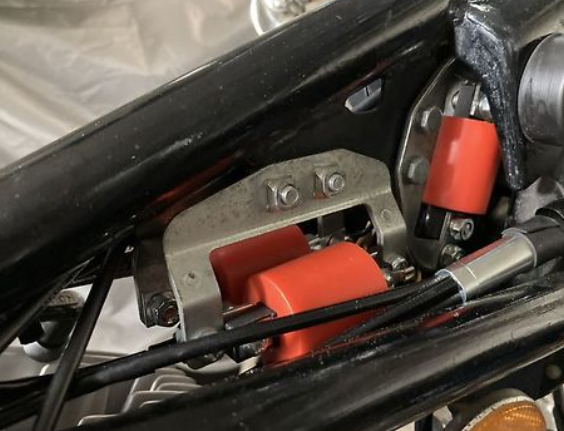 Close-up of a mechanical component with red and silver parts on a vehicle.