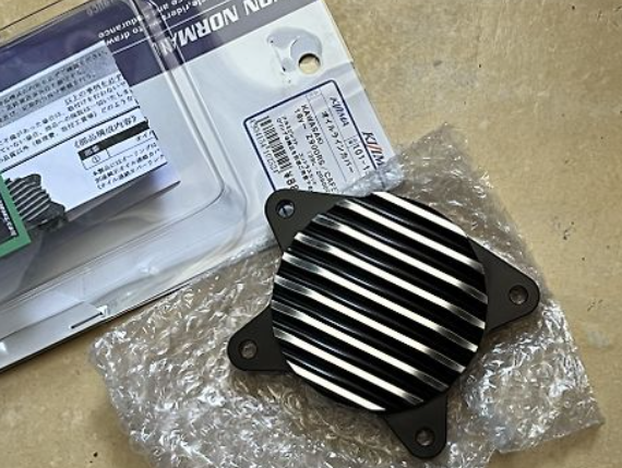 Metallic heat sink on a brown surface with packaging in the background