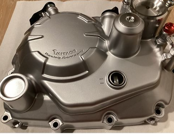 Metallic engine cover with 'KTM' branding on a plain background