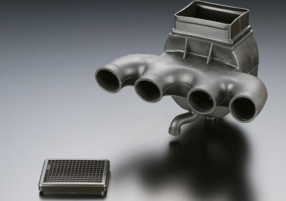 Metallic exhaust manifold and grid on a gray background