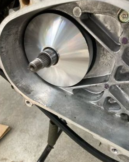 Close-up of a mechanical component with a metal gear and shaft on a gray background