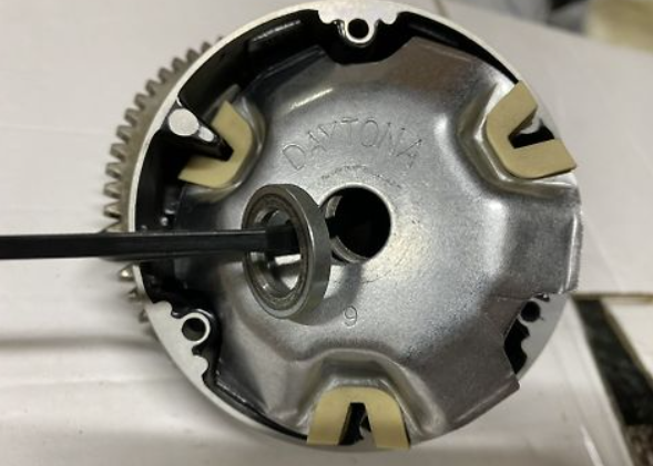 Close-up of a mechanical component with gears and a central shaft on a white background.