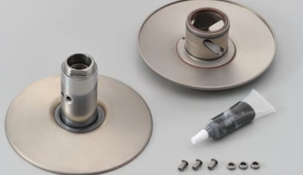 Mechanical components including two metal discs and a tube of grease on a light gray background