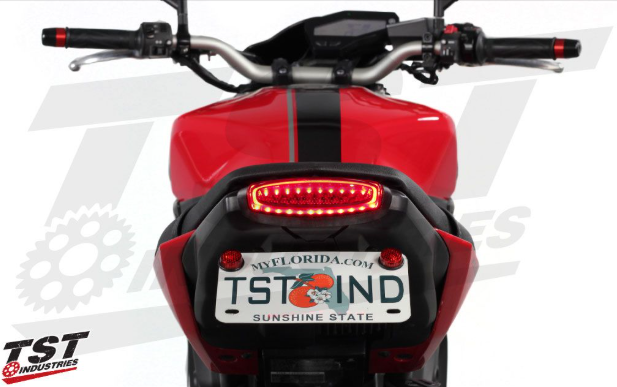 Close-up of a red motorcycle with a Florida license plate on a white background