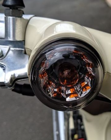Close-up of a motorcycle headlight with a blurred background