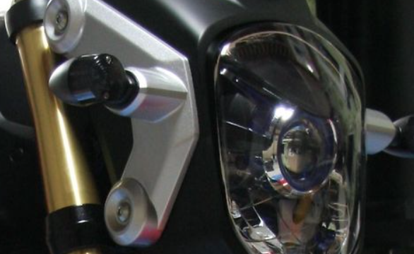 Close-up of a motorcycle headlight with a blurred background