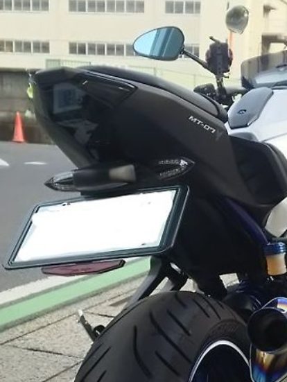Close-up of a black motorcycle with visible branding on a street.