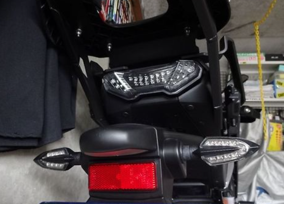 Close-up of a motorcycle's headlight and taillight in an indoor setting