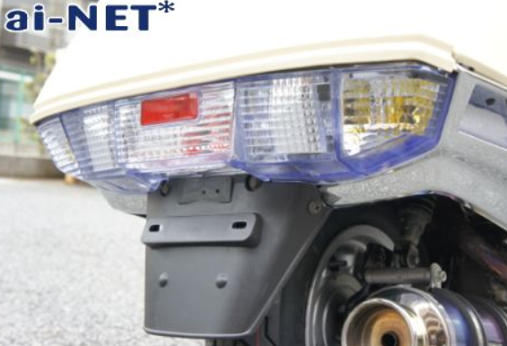 Close-up of a vehicle's rear light system with 'ai-NET' branding.