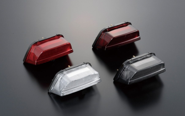 Four motorcycle lights on a dark reflective surface