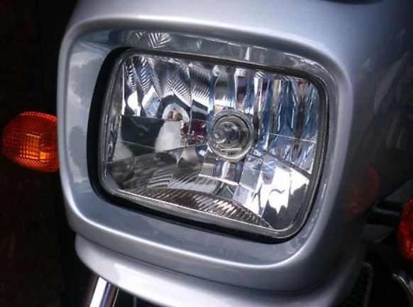 Close-up of a motorcycle headlight with a blurred background