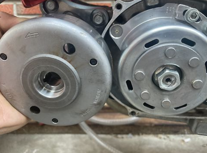 Close-up of two metal pulleys held together by a hand.