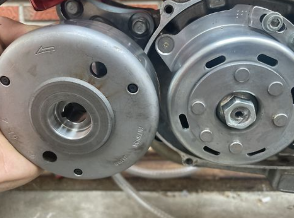 Close-up of two metal pulleys held together by a hand.