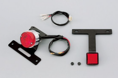 Motorcycle light assembly with red lens and wiring on a gray background