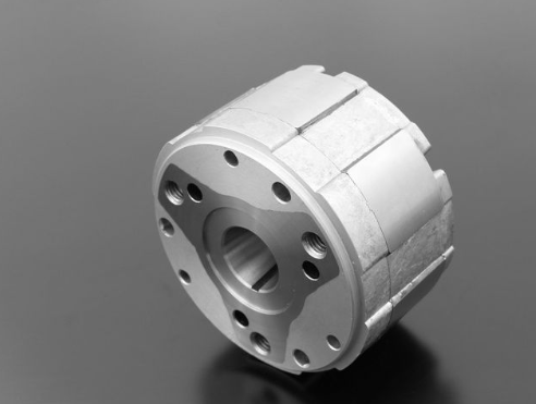 Metallic cylindrical component on a gray background