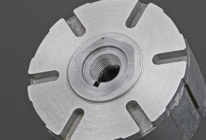 Close-up of a metallic cylindrical component with threaded center on a dark background