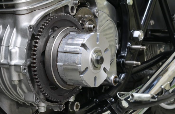 Close-up of a motorcycle engine with gears and metal components.