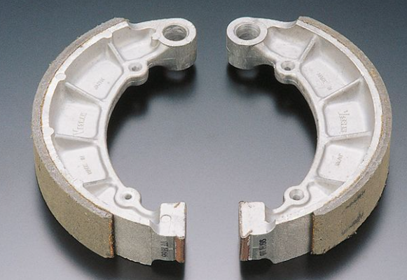 Two brake shoes on a gray background