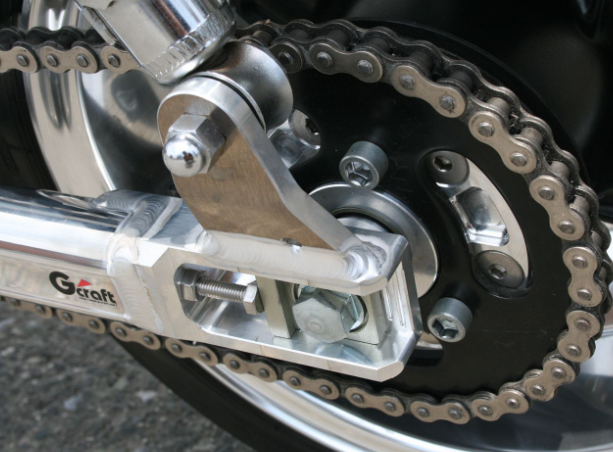 Close-up of a motorcycle chain and sprocket with 'Gaertt' branding.