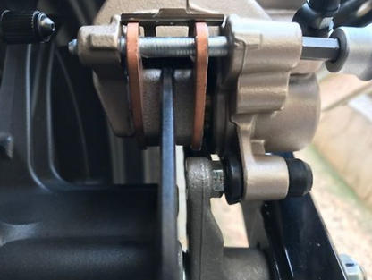 Close-up of a mechanical component, possibly a gear or pulley system, with metal parts and bolts.